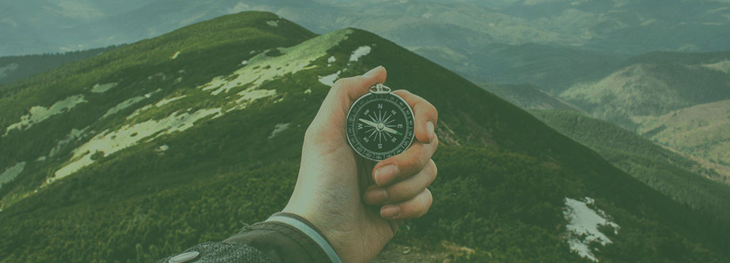 Hand holding compass, green tint. Thriving In Dynamic Times, IT innovation, by Charlie Feld.